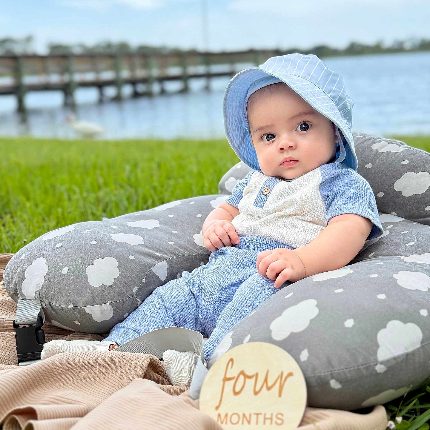 Zayn Loaiza is registered to the contest to win money with this photo: baby, blanket, blue_clothing, child, cloud_pattern, cute, four_months, grass, infant, lake, milestone, nature, outdoor, pier, pillow, portrait, sitting, sunhat, windmill, wooden_sign