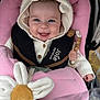 baby, smiling, knitted_hoodie, bear_ears, pink_blanket, stroller, plush_toy, pacifier, baby_clothing, child, happy, cute, infant, seat_harness, wooden_beads, toy_flower, closeup, face, portrait, baby_accessories