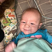 Karsyn joined the competition — help win amazing prizes! baby, infant, smile, blanket, pillow, animal_print, pacifier, blue_shirt, bed, cozy, cute, child, person, resting, happy, indoors, soft_lighting, head, face, young