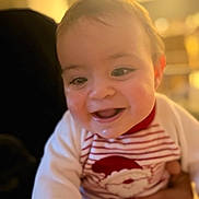 Nahuel a rejoint le concours — aidez-le/la à gagner de superbes lots ! baby, cheerful, child, closeup, cute, drool, face, hand, happy, holiday_clothing, indoor, infant, pajamas, person, portrait, santa_clothing, smile, striped_clothing, warm_lighting, young_child