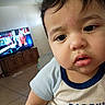 Andres joined the competition — help win amazing prizes! baby, child, infant, portrait, close_up, face, eyes, expression, curious, indoor, living_room, television, cabinet, furniture, shirt, clothing, short_sleeves, sitting, home, photography