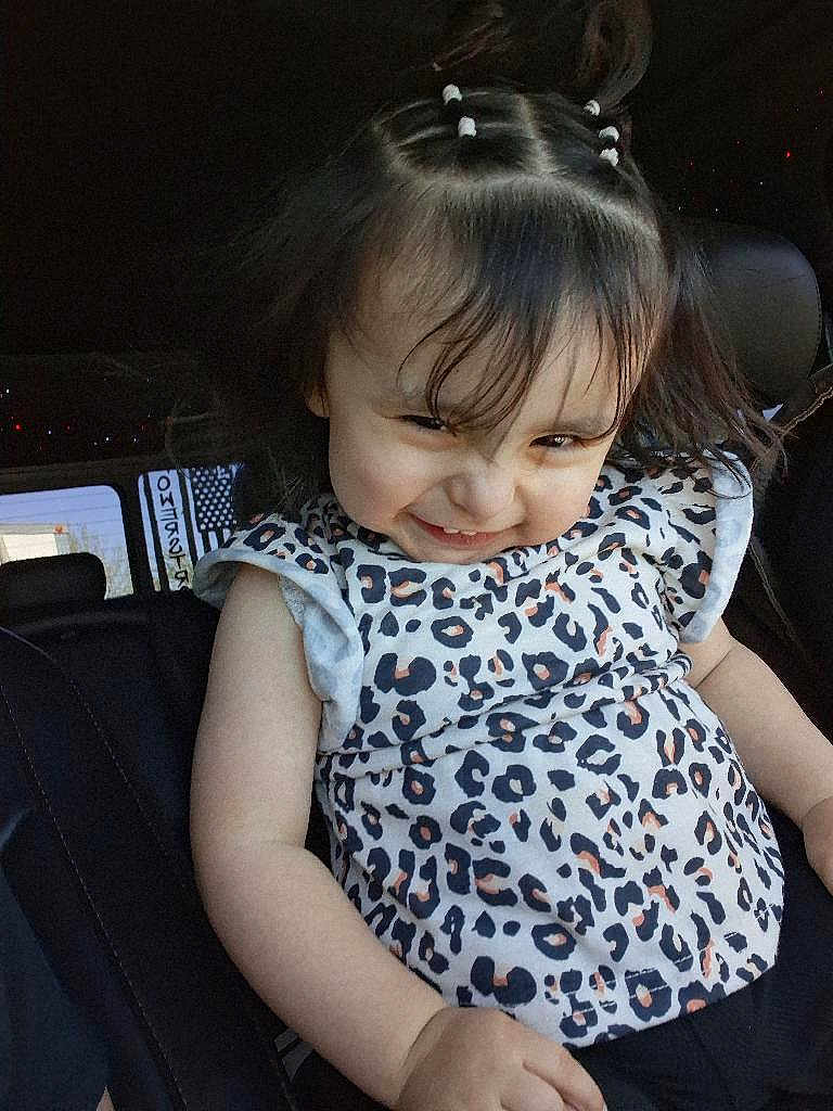 Amy joined the competition — help win amazing prizes! toddler, child, smile, hair_ties, leopard_print, shirt, car_seat, seat, indoor, person, cute, happy, portrait, face, childhood, baby, clothing, sitting, funny_face, playful