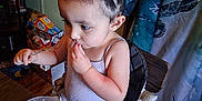 Amy is registered to the contest to win money with this photo: toddler, child, high_chair, braided_hair, rice, plastic_container, spoon, eating, table, curtain, indoor, flooring, snacks, food, person, clothing, hair, seat, home, meal