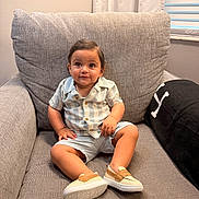 Al Amir is registered to the contest to win money with this photo: toddler, child, armchair, clothing, striped_shirt, shorts, shoes, smile, indoor, curtains, window, blinds, cozy, homedecor, person, portrait, cute, happy, sitting, baby