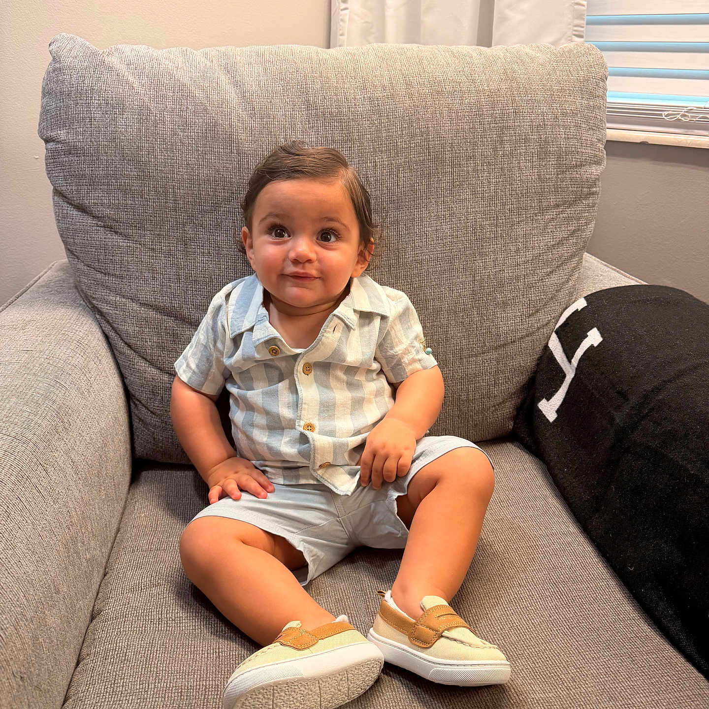 Al Amir is registered to the contest to win money with this photo: toddler, child, armchair, clothing, striped_shirt, shorts, shoes, smile, indoor, curtains, window, blinds, cozy, homedecor, person, portrait, cute, happy, sitting, baby