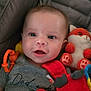 baby, infant, smiling, face, eyes, plush_toy, fox_toy, red_toy, pacifier, clothing, shirt, motorcycle_print, text_on_clothing, baby_toys, soft_toys, child, closeup, indoor, cushion, happy