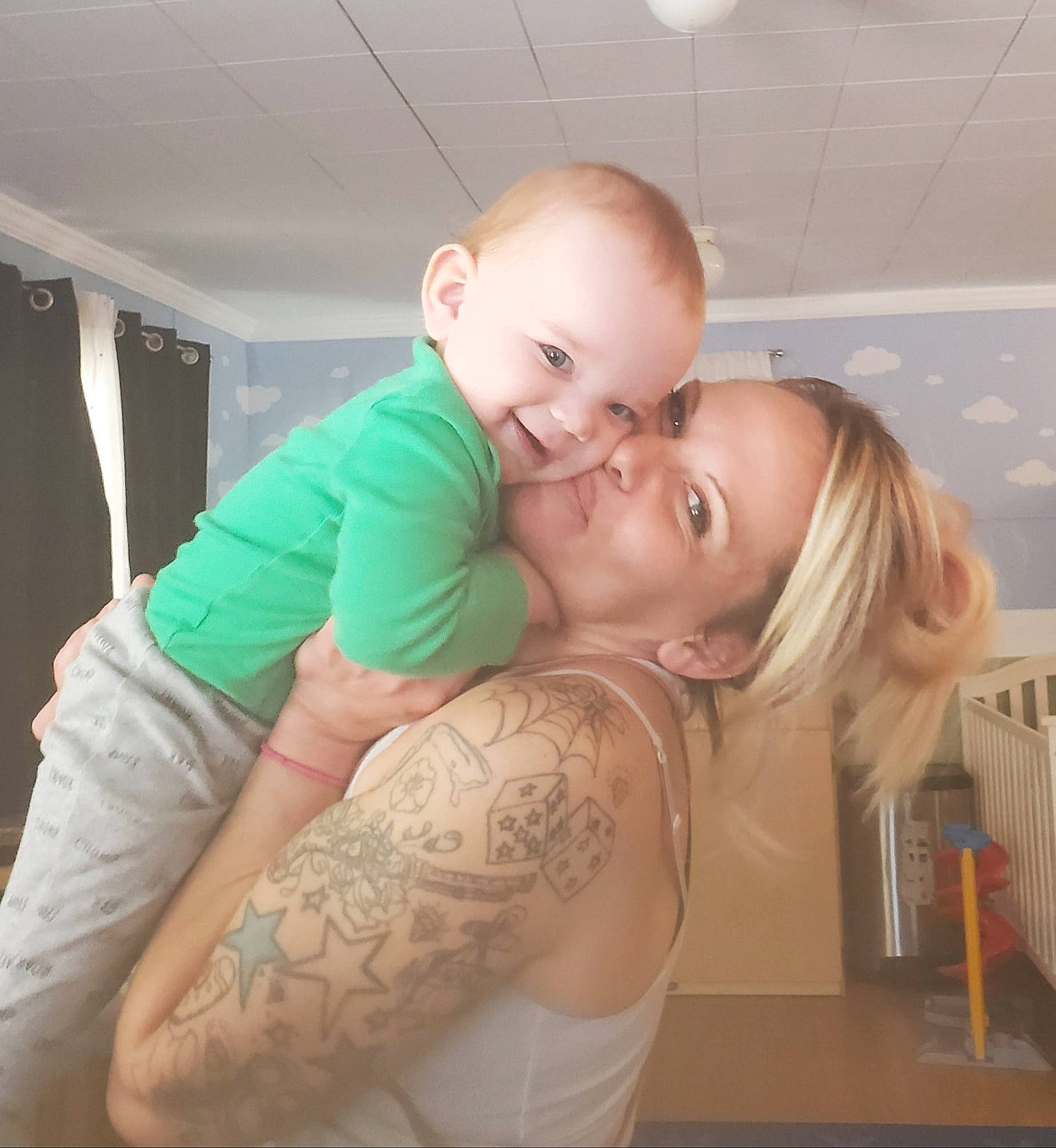 Bradley is registered to the contest to win money with this photo: abdomen, arm, baby, blond, cheek, chest, child, elbow, hair, hug, interaction, joint, mouth, muscle, neck, person, shoulder, skin, tattoo, toddler