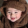 Jack is registered to the contest to win money with this photo: baby, infant, child, smiling, hood, brown_fur, fuzzy_jacket, cute, rosy_cheeks, close_up, portrait, eyes, teeth, happy, cozy, zipper, fabric_texture, warm_clothing, blanket, laying_down