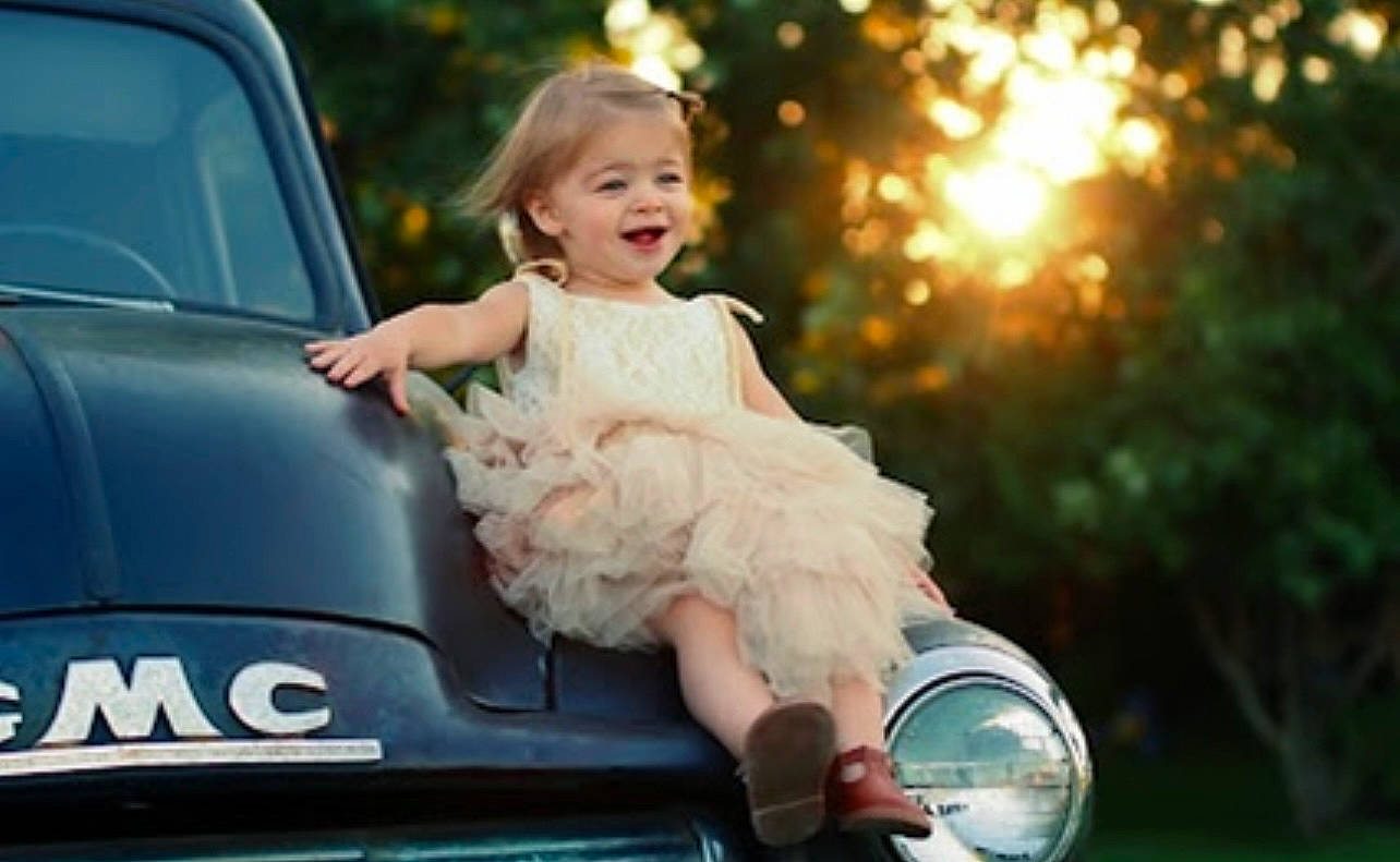 Hanna is registered to the contest to win money with this photo: automotive_design, automotive_exterior, automotive_lighting, blond, car, dress, event, family_car, flash_photography, grass, happy, light, motor_vehicle, people_in_nature, person, photograph, plant, smile, toddler, vehicle