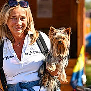 Tresor a rejoint le concours — aidez-le/la à gagner de superbes lots ! animal, backpack, blond_hair, casual_clothing, cute, daytime, dog, happy, holding, leisure, outdoor, person, pet, portrait, small_dog, smiling, sunglasses, sunlight, woman, yorkshire_terrier