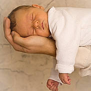 Gabriel participe au concours pour gagner de l'argent avec cette photo : newborn, baby, sleeping, hand, white_clothing, cozy, peaceful, infant, portrait, closeup, skin, relaxation, child, soft_light, warm_tones, adult_hand, texture, background, cute, tenderness
