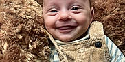 Gabriel a rejoint le concours — aidez-le/la à gagner de superbes lots ! baby, smiling, face, infant, blanket, corduroy, overalls, striped_shirt, happy, cute, child, portrait, closeup, soft_texture, warm_colors, cozy, indoors, person, newborn, expressive