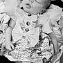 baby, newborn, sleeping, dress, floral_pattern, buttons, ruffles, blanket, infant, peaceful, cute, portrait, small_hands, bare_feet, monochrome, closeup, child, adorable, resting, soft