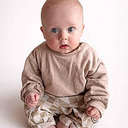 Oliver joined the competition — help win amazing prizes! baby, child, infant, blue_eyes, beige_clothing, checkered_pants, sitting, barefoot, cute, portrait, indoors, soft_lighting, curious_expression, small_hands, round_face, casual_wear, studio_shot, minimalist_background, young, person