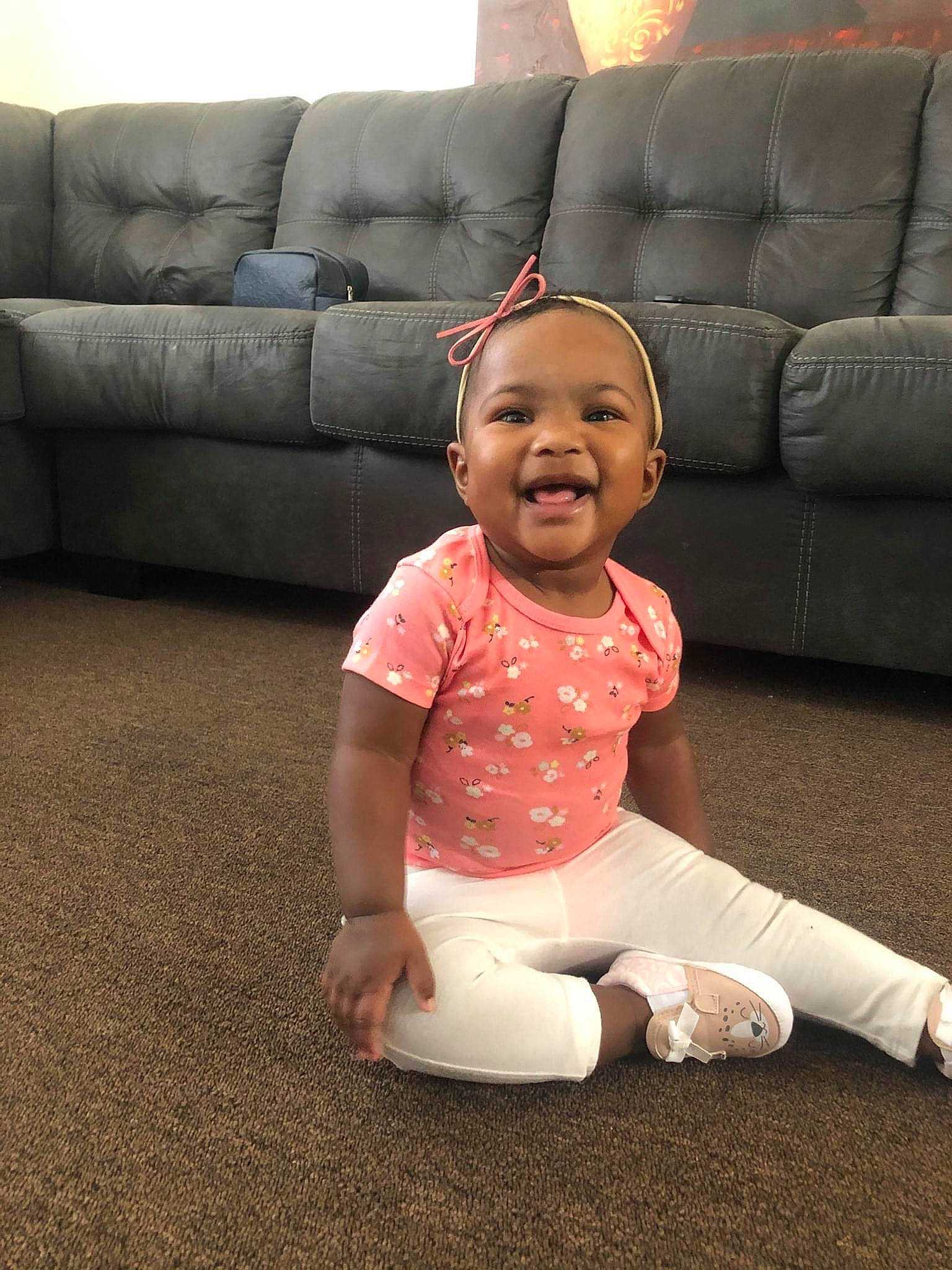 Keniah Lewis joined the competition — help win amazing prizes! baby, baby_toddler_clothing, barefoot, child, comfort, couch, floor, flooring, foot, fun, happy, human_leg, joy, knee, living_room, person, sitting, sleeve, smile, textile