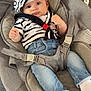 baby, infant, child, striped_clothing, sailor_hat, pom_pom, jeans, white_socks, baby_rocker, gray_fabric, seat_belt, wood_floor, indoor, cute, portrait, person, young_child, casual_clothing, seated, curious_expression