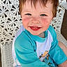 toddler, child, smiling, blue_shirt, shorts, white_chair, woven_chair, happy, outdoor, cute, face, rosy_cheeks, sitting, young_child, portrait, casual_clothing, daylight, skin, hair, text_overlay