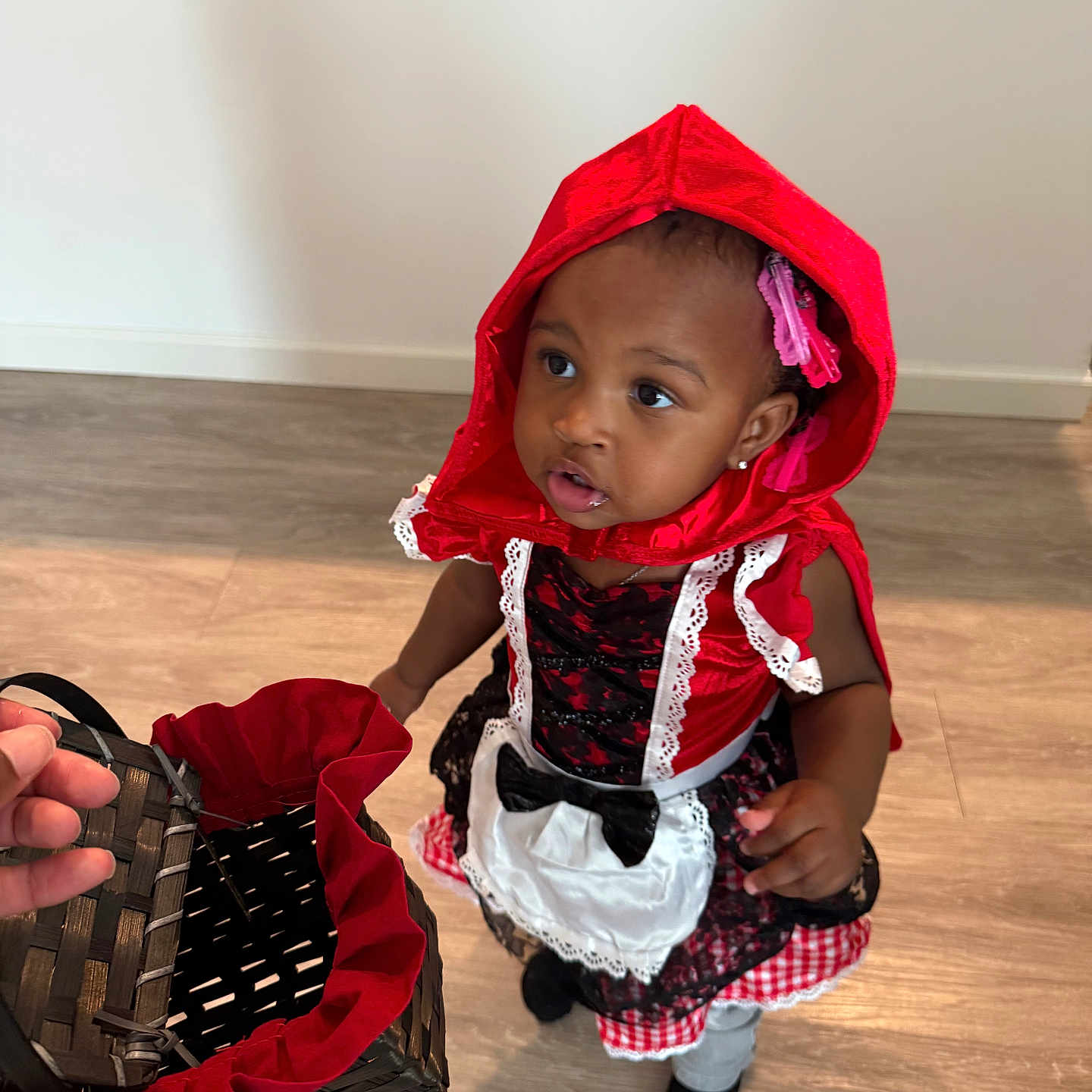 Kamya joined the competition — help win amazing prizes! basket, black_socks, bright_colors, child, costume, curious, dress, floor, girl, hair_clips, hand, indoor, lace, looking_up, person, playful, portrait, red_hood, toddler, young_child