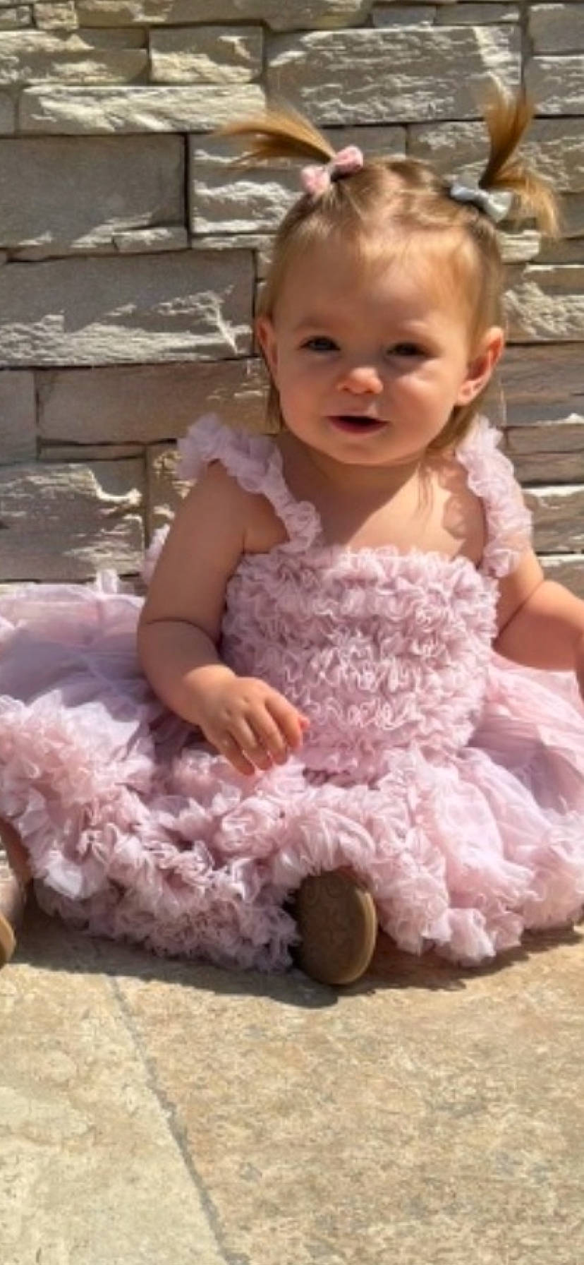 Georgia a rejoint le concours — aidez-le/la à gagner de superbes lots ! baby, bows, child, cute, daylight, dress, fashion, girl, happy, outdoor, person, pink, ponytails, portrait, sitting, smiling, stone_wall, sunlight, toddler, young_child