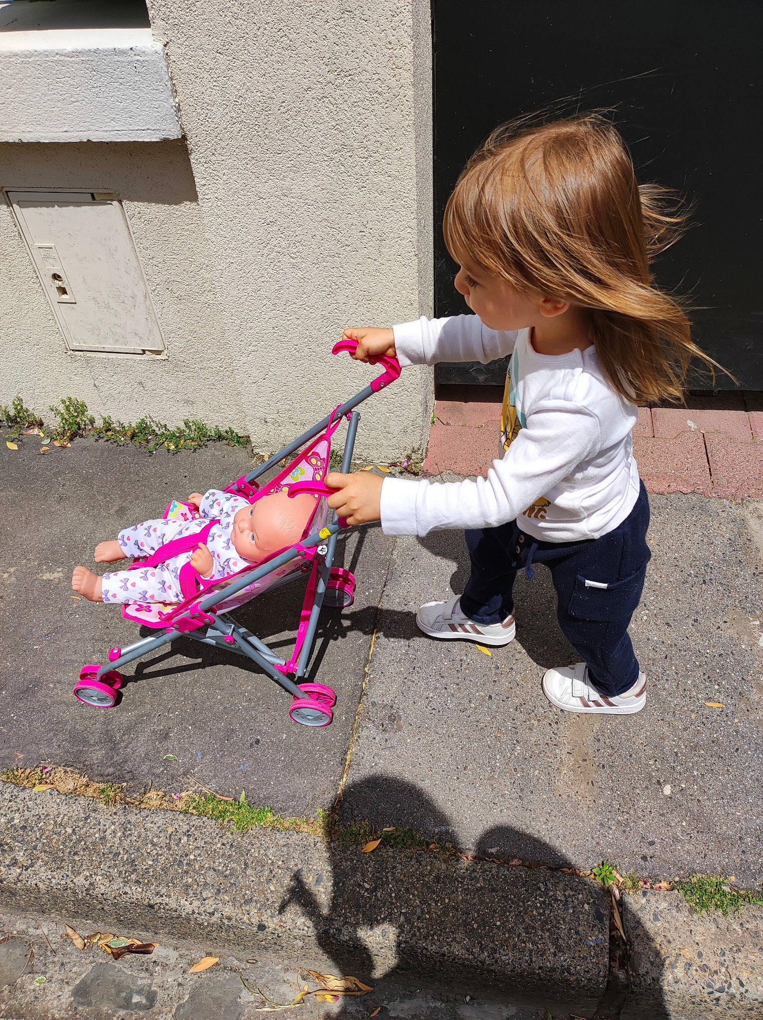 Kyara participe au concours pour gagner de l'argent avec cette photo : asphalt, baby, baby_products, baby_toddler_clothing, child, dress, foot, fun, grass, human_leg, magenta, person, plant, play, road_surface, shoe, sidewalk, sitting, tire, toddler