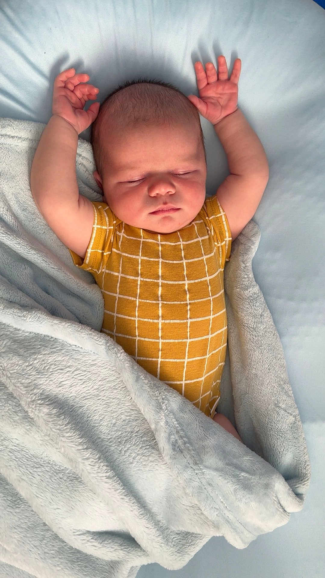 Kal-El joined the competition — help win amazing prizes! baby, sleeping, arms_up, blanket, yellow_clothing, onesie, soft_texture, infant, peaceful, cozy, bed, resting, child, cute, newborn, portrait, indoor, sleepwear, relaxing, toddler