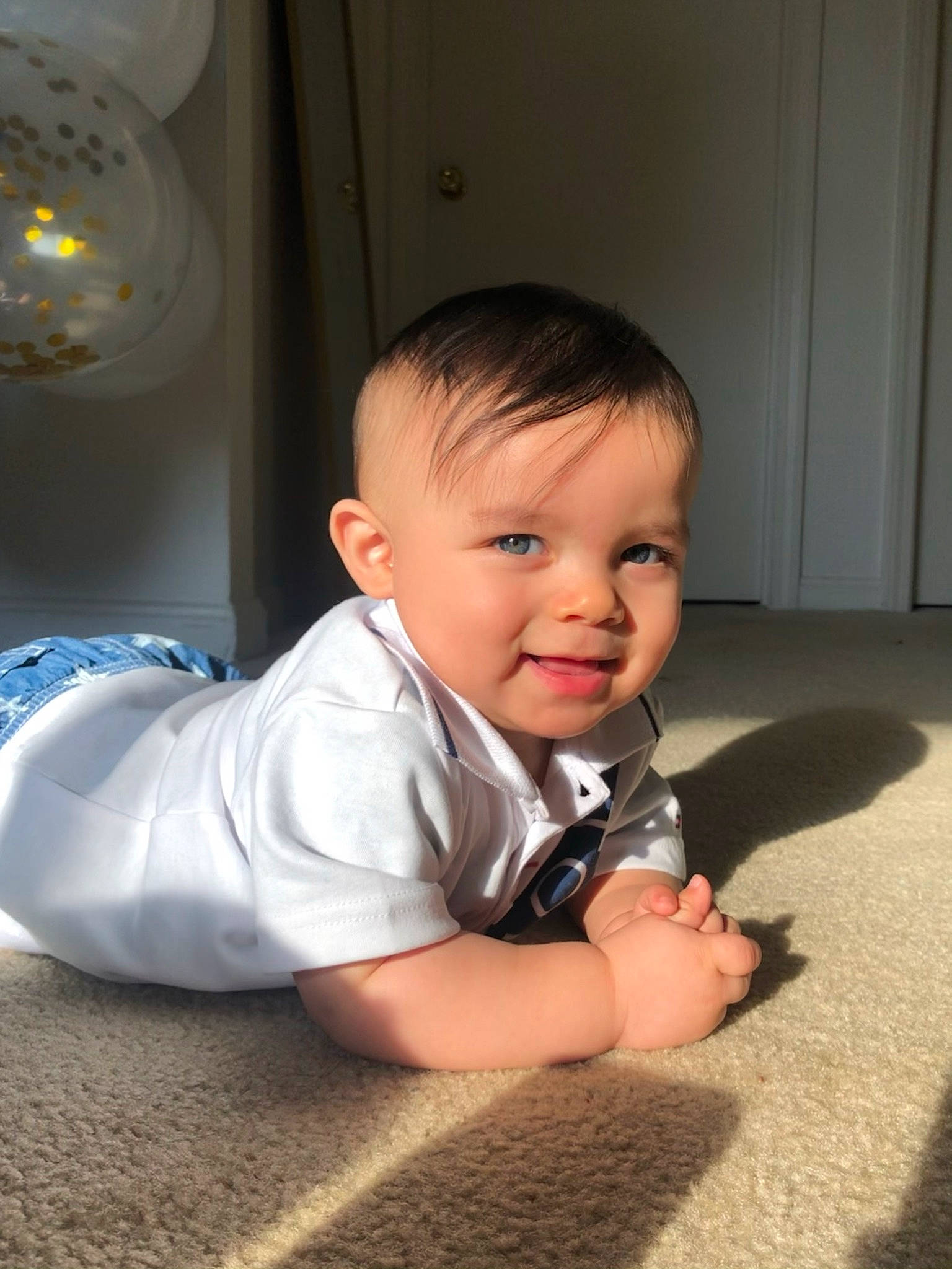Nehemias is registered to the contest to win money with this photo: baby, baby_toddler_clothing, cheek, chin, comfort, door, face, finger, flooring, fun, happy, hardwood, iris, joy, mouth, nose, person, skin, sleeve, smile