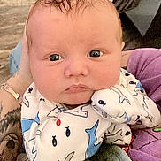 Axel joined the competition — help win amazing prizes! baby, infant, newborn, face, eyes, pajamas, whale_pattern, blanket, arm, tattoo, watch, caregiver, couch, carpet, indoor, portrait, close_up, soft_lighting, cute, curious_expression