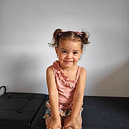 Giuliana a rejoint le concours — aidez-le/la à gagner de superbes lots ! child, girl, pigtails, pink_bows, smile, sitting, bench, floral_shorts, pink_top, indoor, cute, portrait, happy, minimalist, fashion, young, hands, face, hairstyle, casual