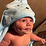 baby, infant, hooded_towel, blue_towel, bath_time, bathroom_tiles, cheeks, dimples, big_eyes, portrait, close_up, bare_chest, arm, hand, soft_fabric, plush, looking_up, cute, newborn, skin