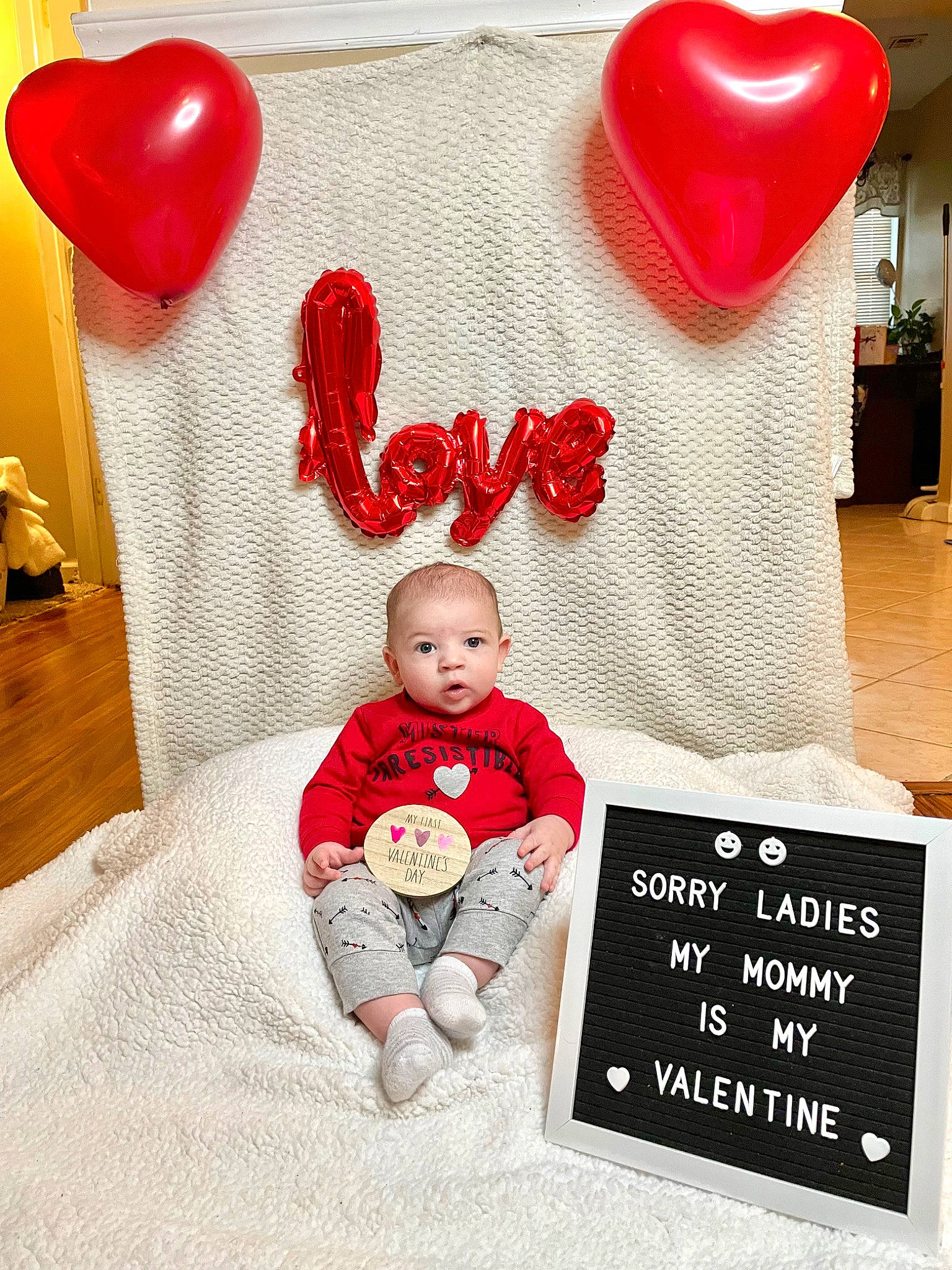 Mateo is registered to the contest to win money with this photo: baby, baby_toddler_clothing, balloon, beauty, child, comfort, flooring, font, happy, material_property, organ, person, photograph, pink, product, red, sleeve, surprise, t_shirt, textile