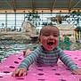 baby, smiling, pool, water, indoor, floating_mat, swimsuit, child, happy, playful, recreation, leisure, water_sports, toddler, fun, paddle, relaxation, summer, splash, joy