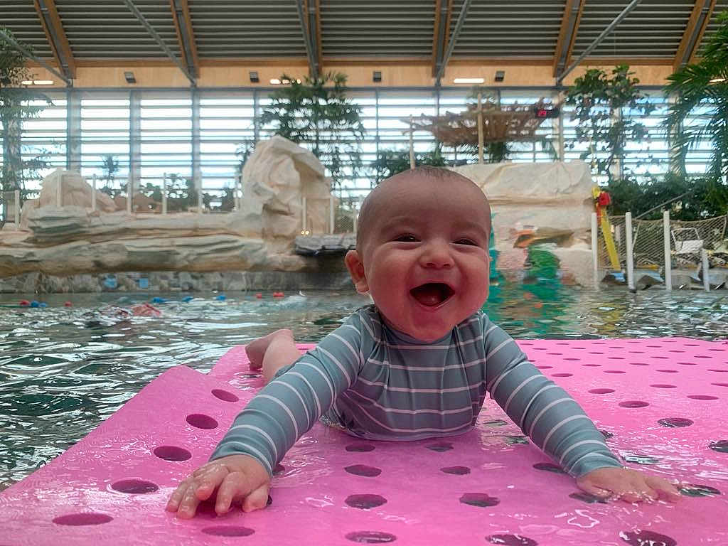 Noah a rejoint le concours — aidez-le/la à gagner de superbes lots ! baby, smiling, pool, water, indoor, floating_mat, swimsuit, child, happy, playful, recreation, leisure, water_sports, toddler, fun, paddle, relaxation, summer, splash, joy