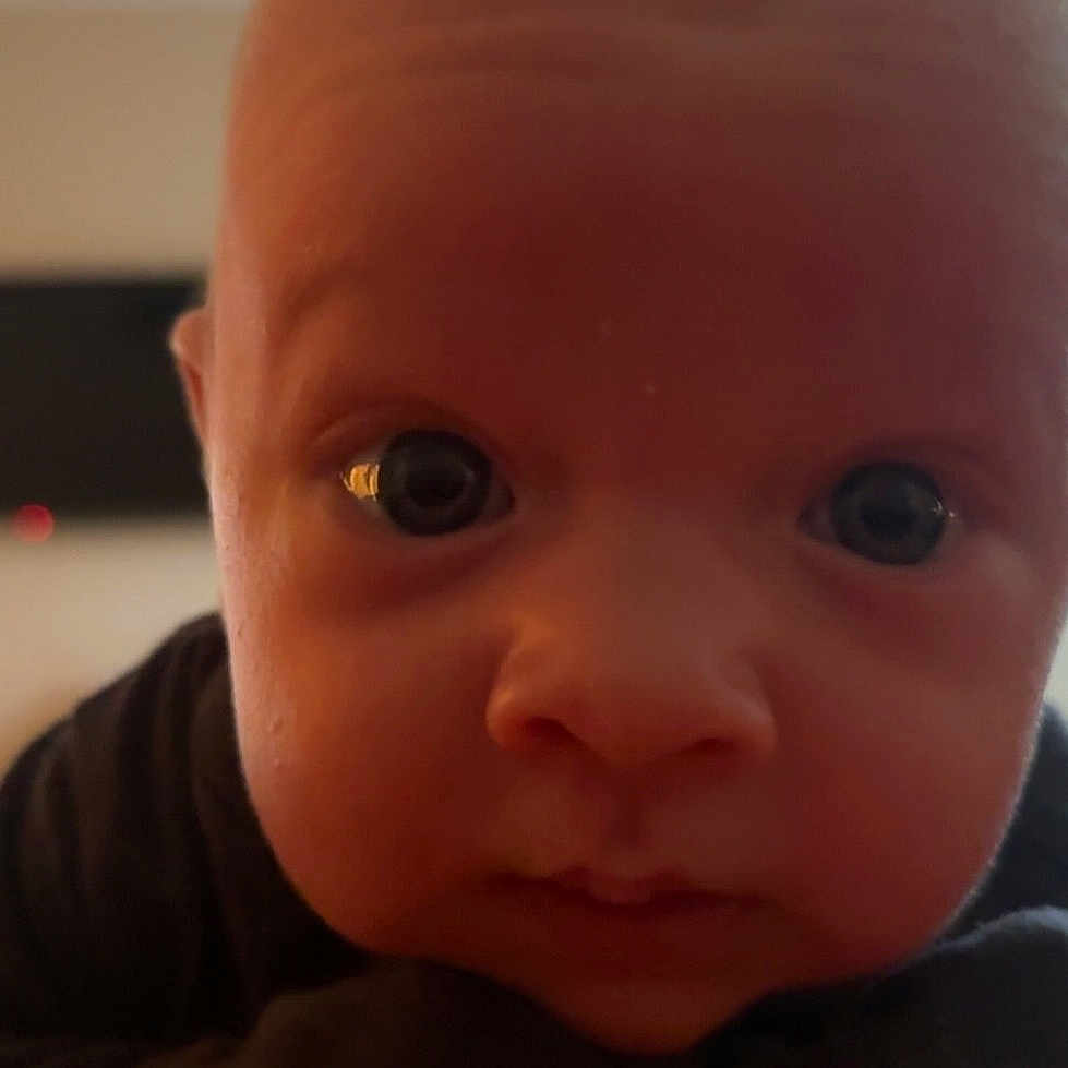 Kase is registered to the contest to win money with this photo: baby, child, closeup, curious, cute, expression, face, focus, front_view, head, human, indoor, infant, looking, person, portrait, skin, soft_light, wide_eyes, young_child