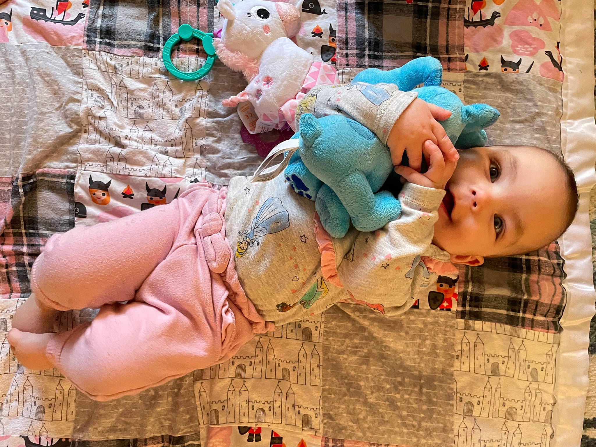 Reagan is registered to the contest to win money with this photo: baby, baby_products, baby_toddler_clothing, cheek, child, doll, happy, human_leg, linens, pattern, peach, person, pink, room, sitting, snapshot, stuffed_toy, textile, thigh, toddler