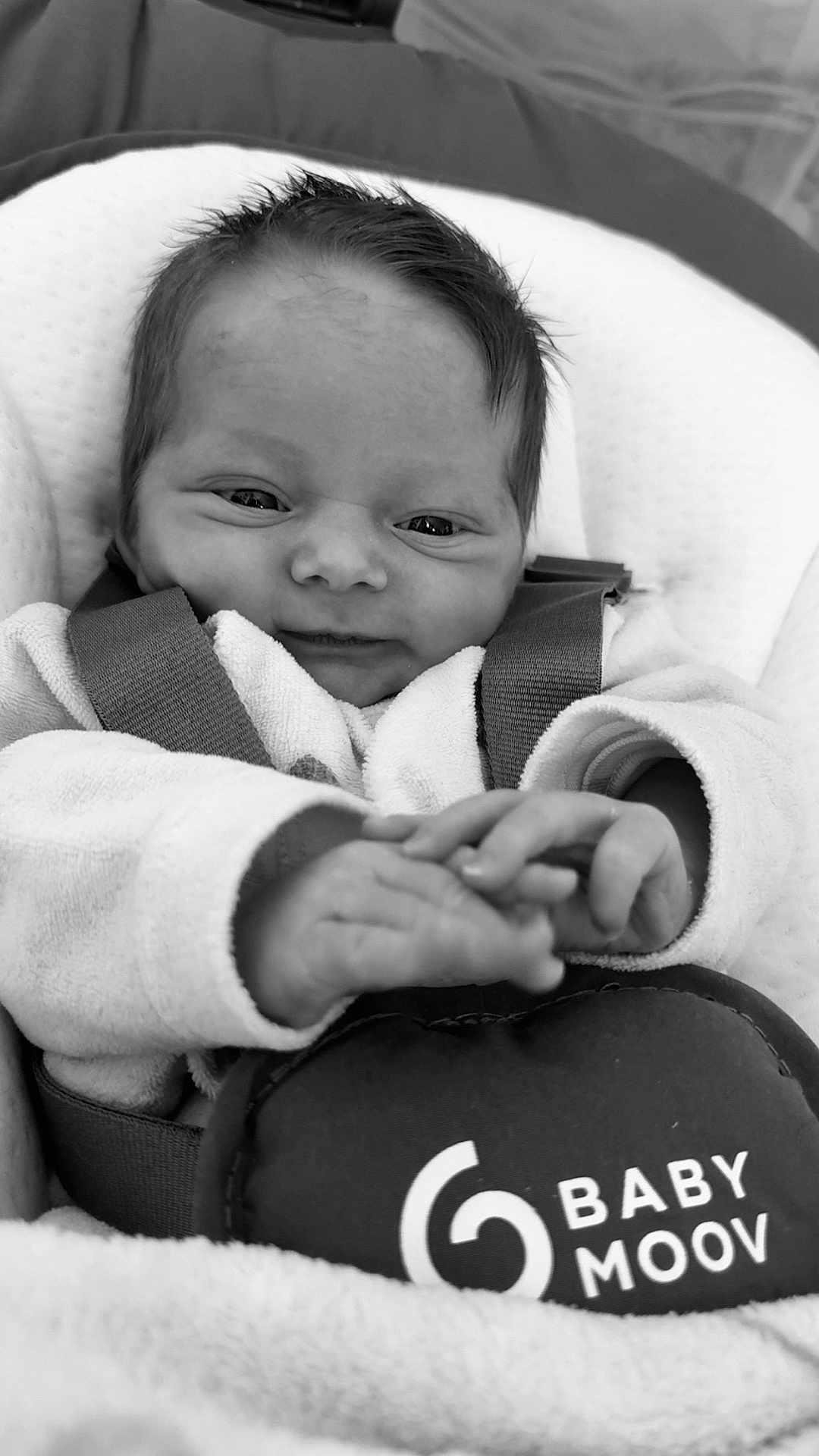 Théa participe au concours pour gagner de l'argent avec cette photo : baby, infant, smiling, black_and_white, cozy, clothing, seat, baby_seat, comfort, face, hands, portrait, cute, child, newborn, soft, fabric, closeup, expression, indoor