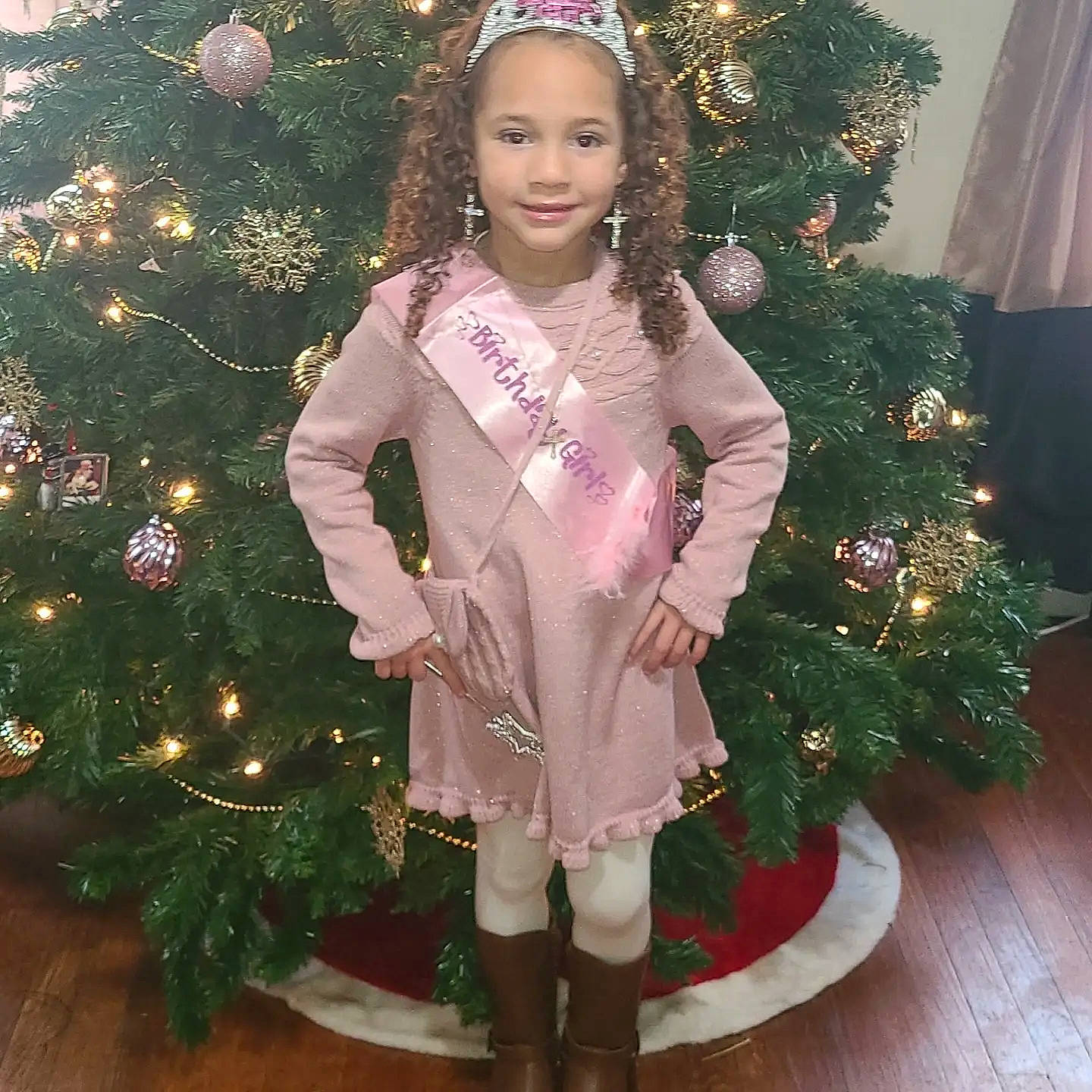 Meliya is registered to the contest to win money with this photo: christmas, christmas_decoration, christmas_ornament, christmas_tree, dress, face, hair, happy, holiday_ornament, human_body, joy, light, ornament, outerwear, person, plant, sleeve, smile, standing, thigh