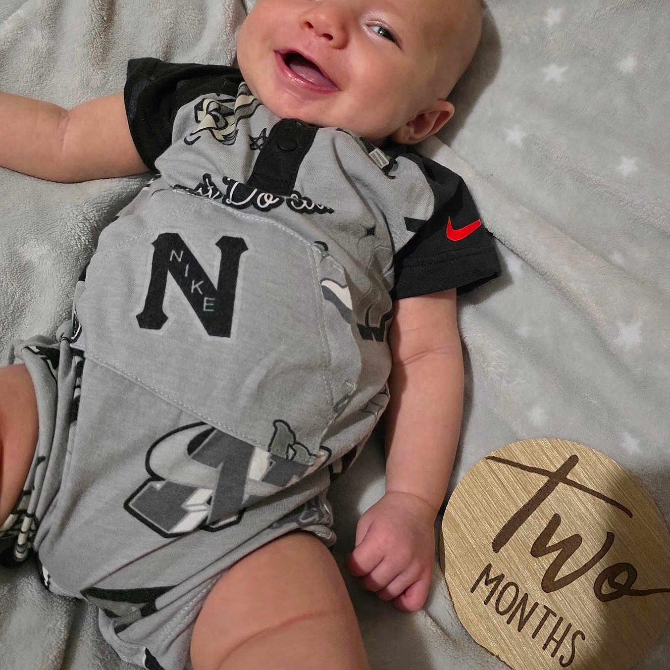 Carson joined the competition — help win amazing prizes! arm, baby, blanket, clothing, fabric, face, foot, hand, happy, head, indoor, infant, leg, pattern, person, sign, skin, smiling, two_months, wooden_sign
