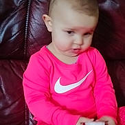 Assia participe au concours pour gagner de l'argent avec cette photo : child, toddler, pink_clothing, nike_logo, leather_sofa, sitting, indoor, portrait, blurry, holding_object, socks, cute, expression, home, casual, candid, seat, young, toy, couch