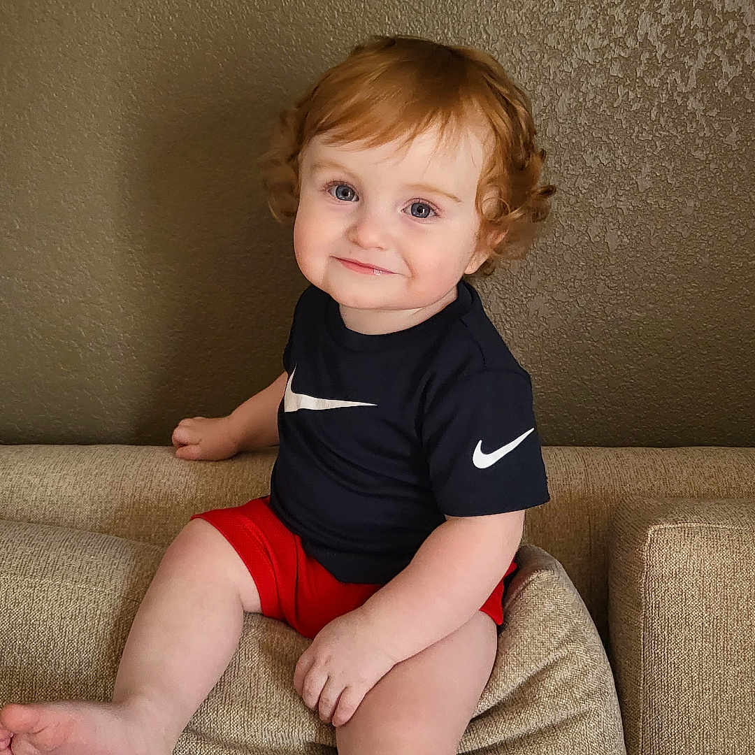 Bentley joined the competition — help win amazing prizes! architecture, baby, bodypart, building, clothing, couch, cushion, face, finger, furniture, hand, head, homedecor, indoors, livingroom, person, photography, portrait, shorts, sitting