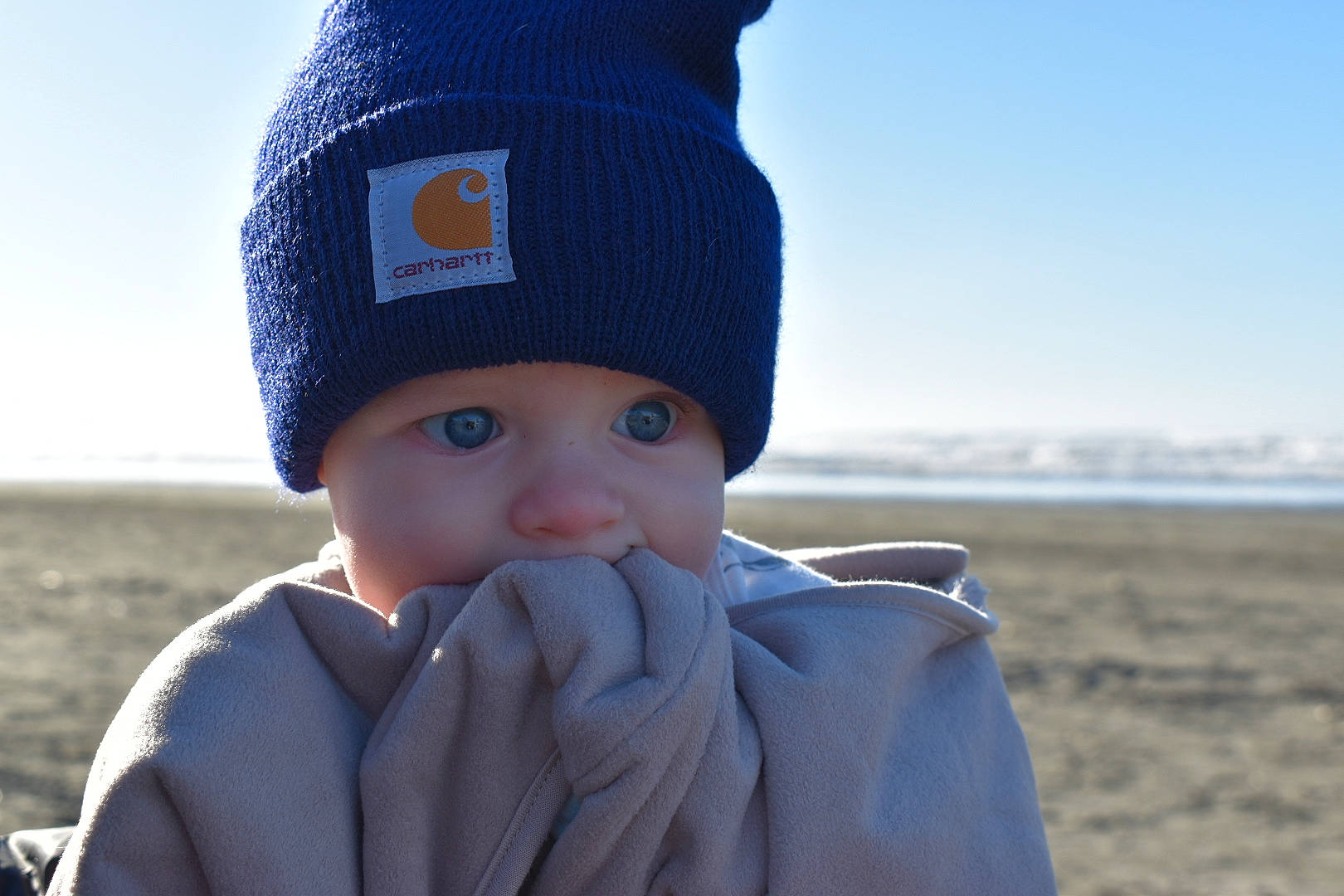 Callan joined the competition — help win amazing prizes! azure, baby, baby_toddler_clothing, beanie, cap, child, clothing, electric_blue, freezing, happy, headgear, headwear, knit_cap, outerwear, person, sky, sleeve, toddler, water, winter