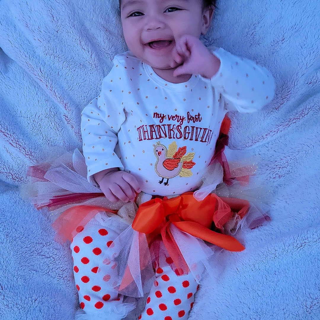 Elsie is registered to the contest to win money with this photo: accessories, applique, baby, blanket, bodypart, clothing, dress, face, finger, hand, happy, hat, head, laughing, newborn, pattern, person, photography, portrait, smile