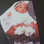 Nay'Omee is registered to the contest to win money with this photo: baby, infant, cutout_photo, white_clothing, headband, hands, feet, adult_hands, background, black_background, text_overlay, sentimental, portrait, clothing, infant_booties, photograph, keepsake, close_up, human, person