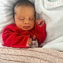 baby, sleeping, blanket, red_clothing, infant, cozy, cute, rest, portrait, child, knit_blanket, indoors, peaceful, newborn, soft_texture, hand, face, closed_eyes, warm, holiday