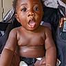 Davell joined the competition — help win amazing prizes! baby, child, car_seat, surprised, wide_eyes, open_mouth, hand, seatbelt, indoors, curly_hair, skin, infant, expression, person, sitting, cute, young_child, diaper, closeup, seat