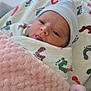 newborn, baby, infant, blanket, swaddle, hat, hospital, bassinet, footprint_pattern, sleepy, wrapped, soft_texture, cute, child, person, face, resting, indoor, cozy, pink