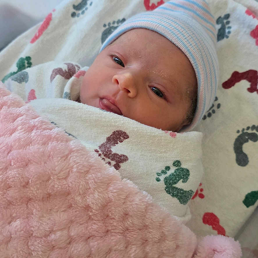 Evangelina joined the competition — help win amazing prizes! baby, bassinet, blanket, child, cozy, cute, face, footprint_pattern, hat, hospital, indoor, infant, newborn, person, pink, resting, sleepy, soft_texture, swaddle, wrapped