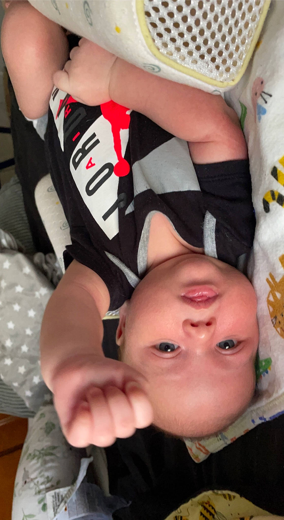 Connor is registered to the contest to win money with this photo: arm, baby, baby_toddler_clothing, black, cheek, chest, child, comfort, elbow, eyelash, finger, gesture, happy, mouth, nose, pattern, person, thigh, thumb, toddler