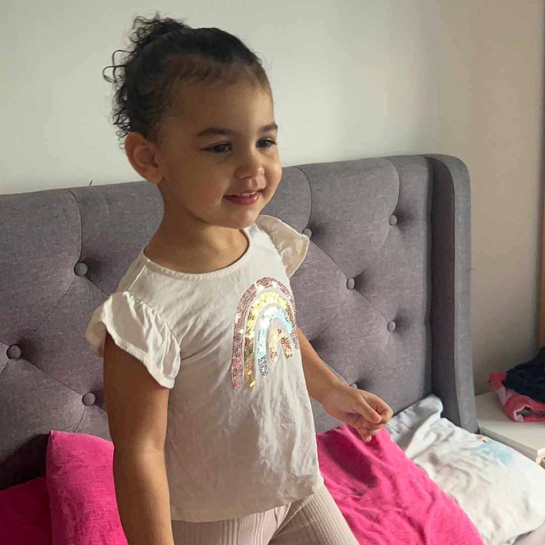Medina-Rose is registered to the contest to win money with this photo: bed, bedroom, child, clothing, couch, cushion, face, female, furniture, girl, head, homedecor, indoors, pants, person, photography, portrait, room, sitting, t_shirt
