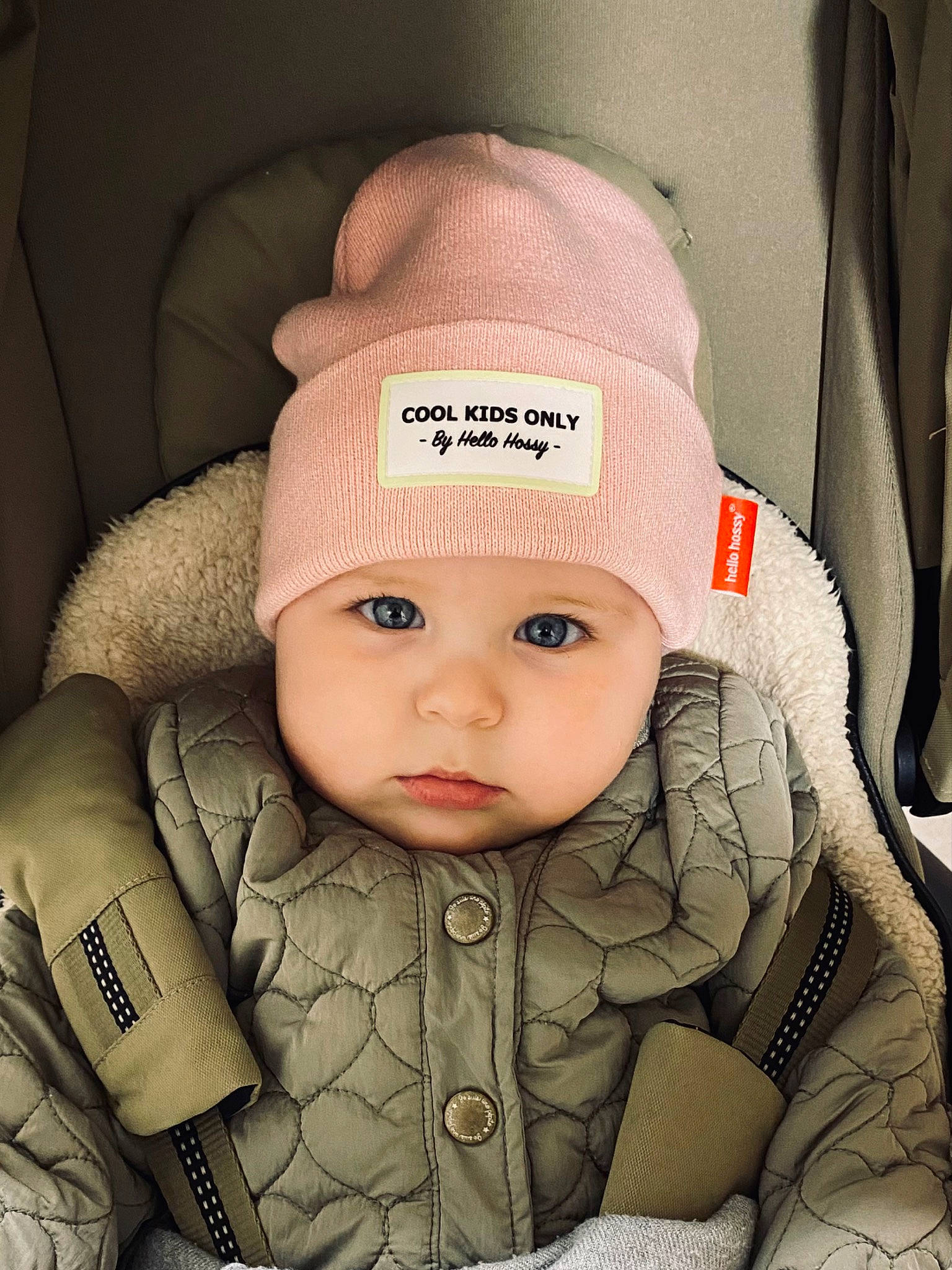 Livia a rejoint le concours — aidez-le/la à gagner de superbes lots ! baby, baby_carriage, baby_products, baby_safety, baby_toddler_clothing, beanie, bonnet, cap, car_seat, cheek, child, comfort, fashion_accessory, hat, headwear, hoodie, knit_cap, person, portrait_photography, sitting