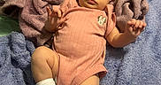 Winter is registered to the contest to win money with this photo: baby, infant, child, portrait, lying_down, blanket, pink_outfit, onesie, socks, smiling, wide_eyed, indoor, nursery, toy, plush_toy, bed, soft_texture, cozy, baby_furniture, photography